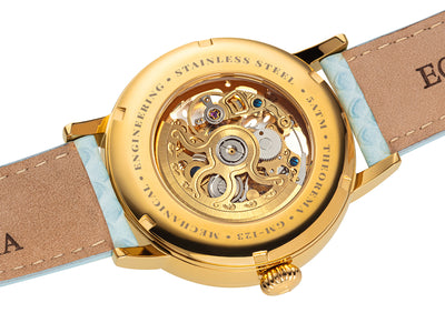 Gold color movement open back to see the inside of the mechanism and gears. 